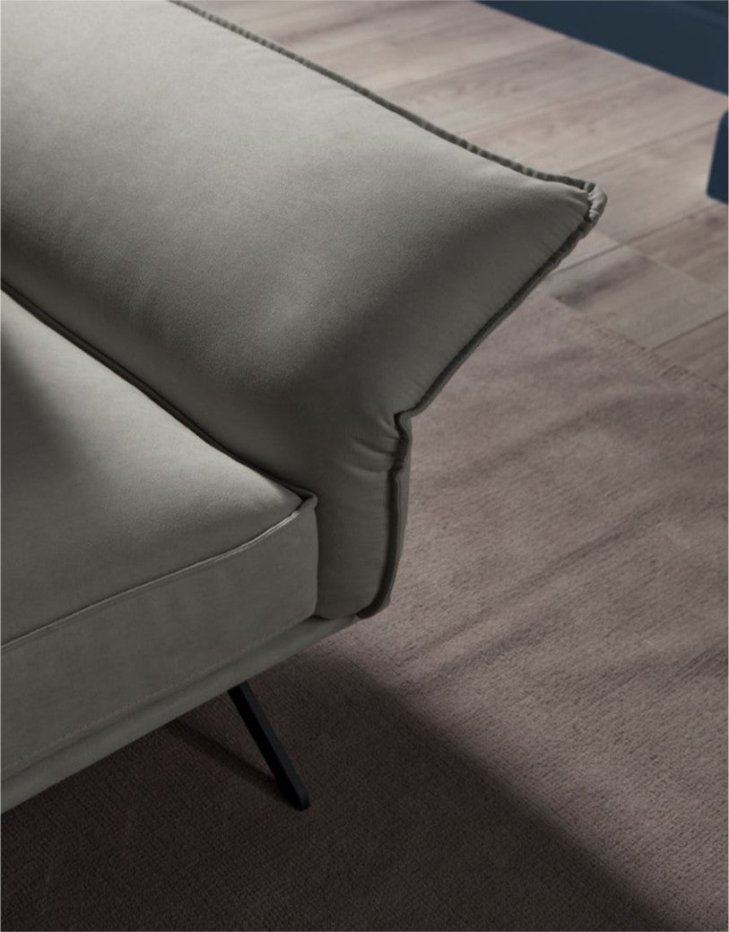 Close-up detail of the Capitolo sofa's cushion stitching and slim metal leg