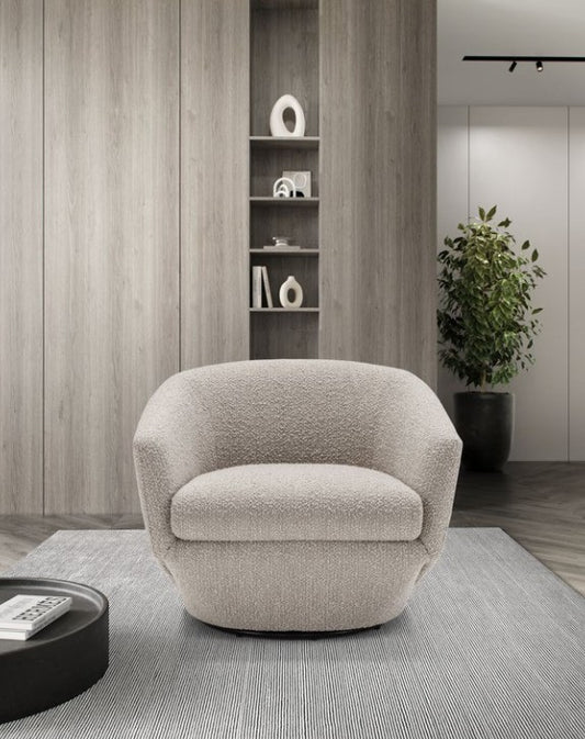 Fracco armchair in textured beige fabric, front view on a striped rug beside a round black coffee table