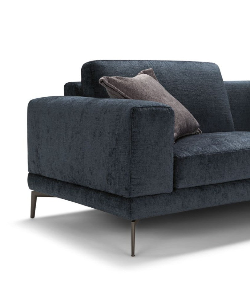 Close-up detail of the squared armrest, cushions, and slim metal leg on the navy sectional sofa