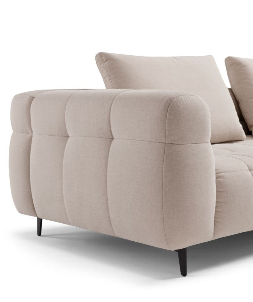 Close-up detail of the Sherry sofa's quilted armrest, back cushion and slim metal leg