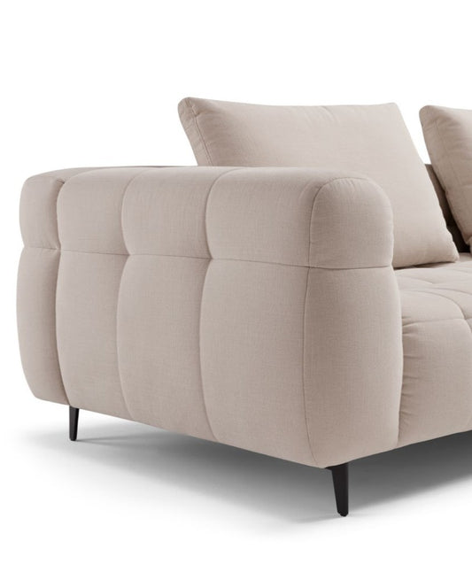 Close-up detail of the Sherry sofa's quilted armrest, back cushion and slim metal leg
