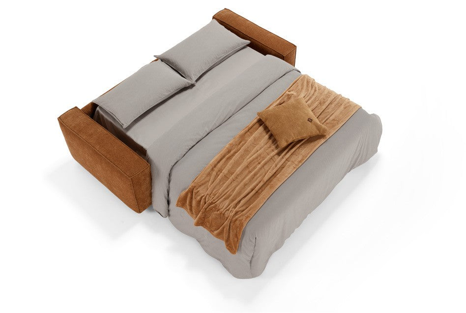 Tesoro sofa bed fully opened into a bed, dressed with grey bedding and a rust throw