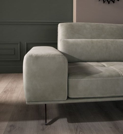 Detail of the Vanoni squared armrest with contrast stitching and slender metal leg