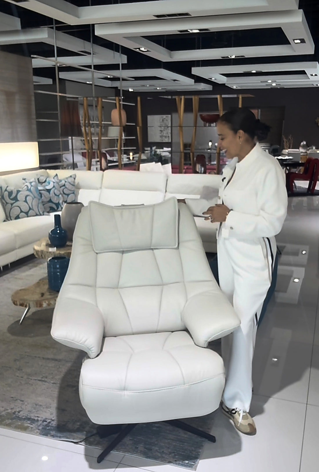 BOGA Style Home team member guiding a client through a recliner chair option in the Miami showroom