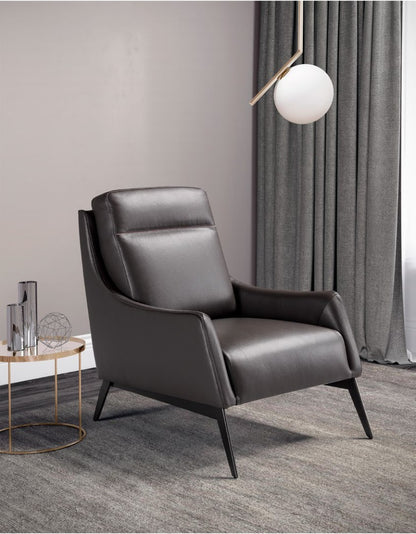 Alicudi armchair in dark brown leather on tapered metal feet beside a round brass side table and globe pendant lamp