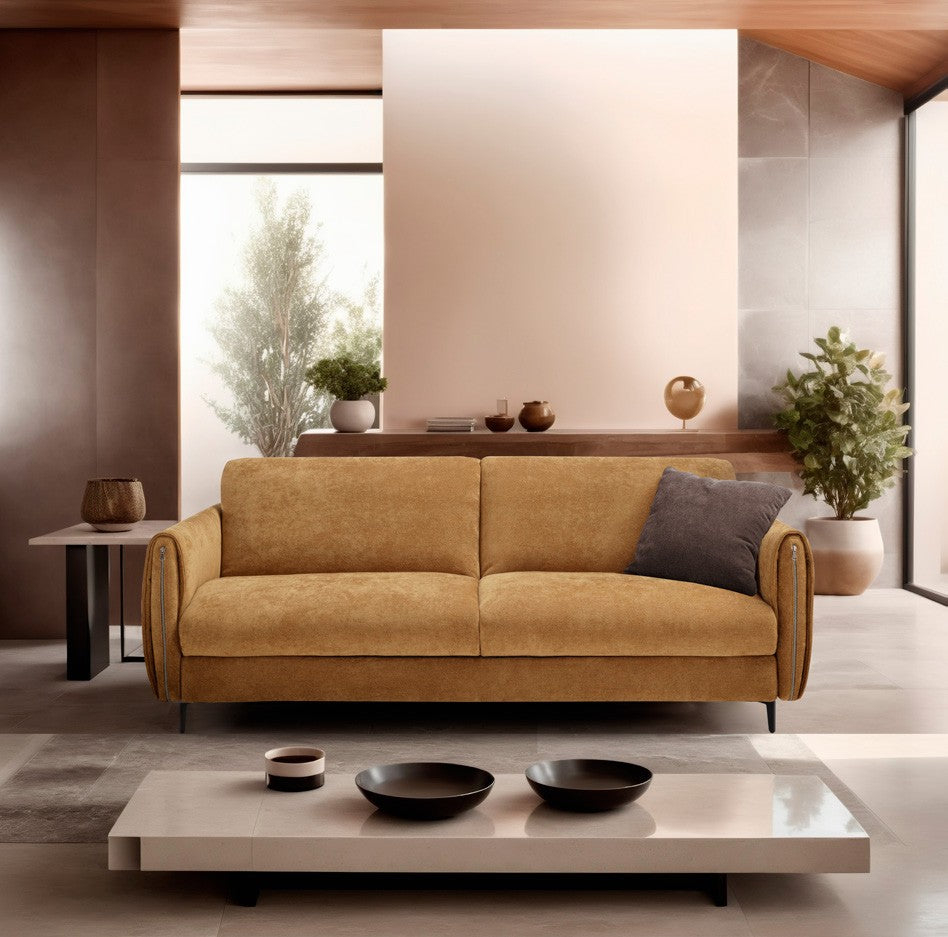 Angel sofa bed in ochre fabric with rounded armrests and slim black metal legs in a warm contemporary living room
