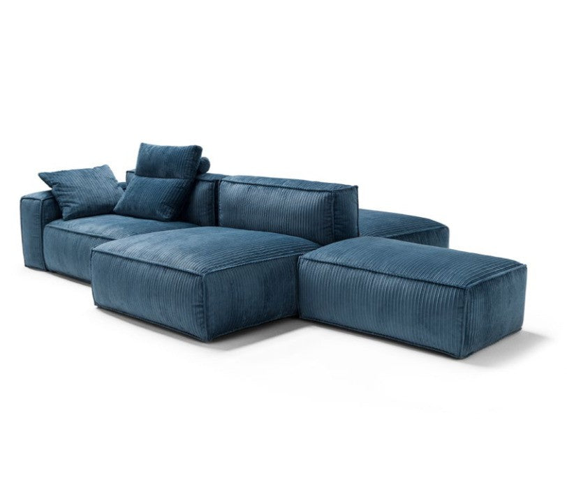 Studio cutout of a blue modular sectional sofa with two loose ottomans arranged at an angle
