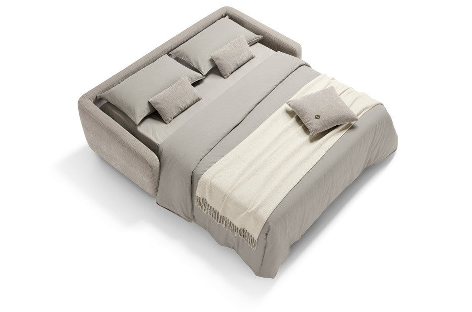 Baca sofa bed opened into a double bed, dressed with grey bedding, pillows and a cream throw