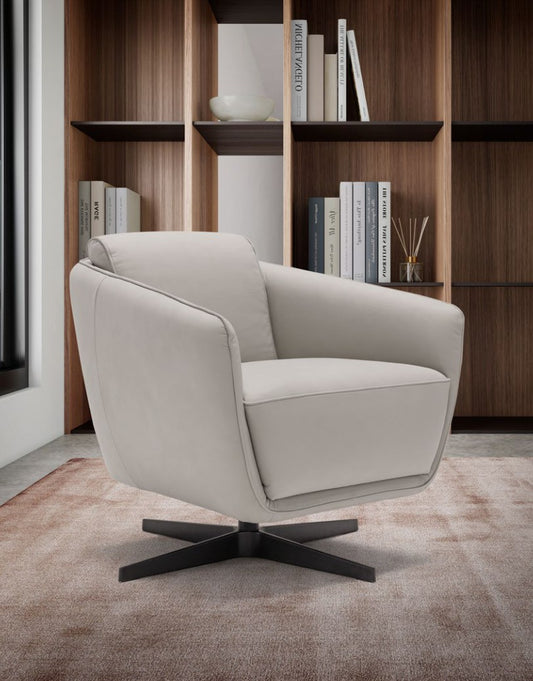 Benati armchair in light grey leather with black metal base, three-quarter view in a library setting with wooden bookshelves