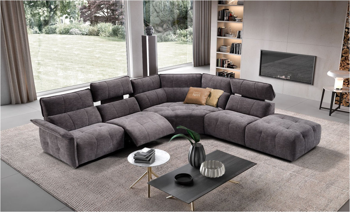 Borg modular sectional sofa in grey quilted fabric with reclined seat, corner element and terminal ottoman in a bright living room