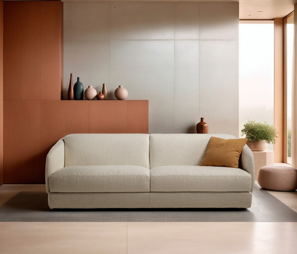 Canto three-seater sofa bed in white boucle fabric with a mustard cushion against a terracotta wall