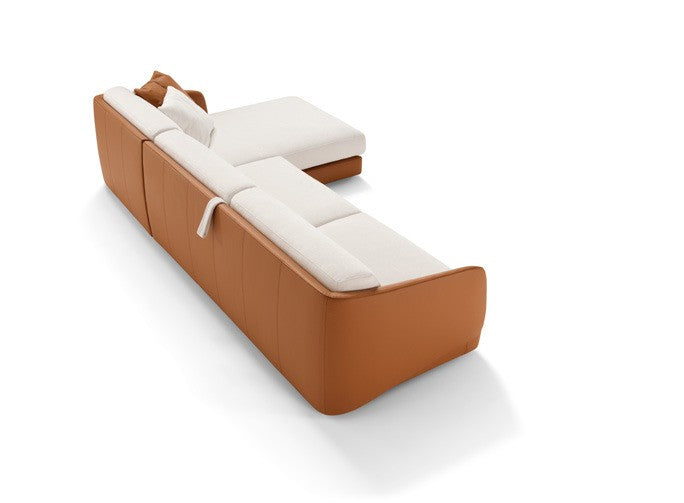 Rear view of the Canto sectional sofa bed with chaise longue, curved cognac armrests and white cushions