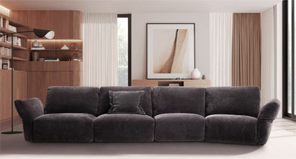 Charcoal grey fabric modular sofa with gently curving silhouette in a wood-paneled living room