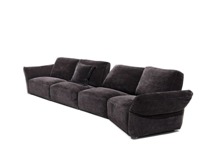 Charcoal grey fabric modular sofa, three-quarter cutout view showing low curved armrest