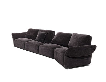 Charcoal grey fabric modular sofa, three-quarter cutout view showing low curved armrest