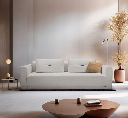 Cynar sofa bed in white textured fabric in a contemporary living room with a copper coffee table and floor lamp