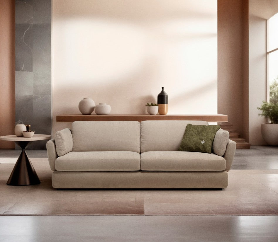 Dambo three-seater sofa bed in beige fabric against a peach wall with a green accent cushion