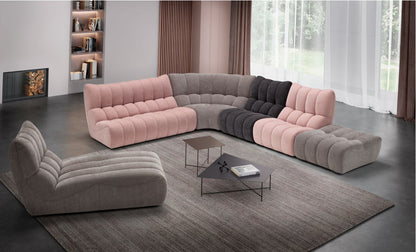 Deseo modular sofa in pink, grey and charcoal quilted fabric arranged in a corner composition with round corner module and chaise longue in a contemporary living room