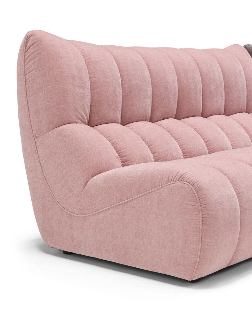 Close-up of the Deseo sofa's deep quilting and embossed side stitching in pink fabric