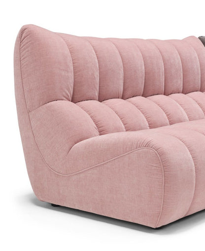Close-up of the Deseo sofa's deep quilting and embossed side stitching in pink fabric