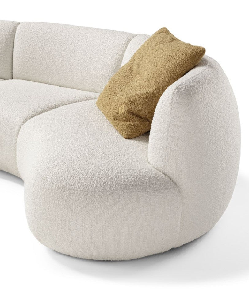 Close-up detail of the Elisa sofa's rounded armrest and seat cushion in ivory bouclé