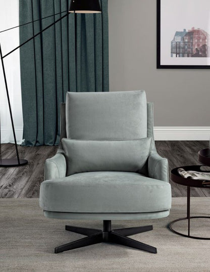 Filicudi armchair front view showing the lumbar cushion, rounded seat cushion and four-star swivel base beside a round side table