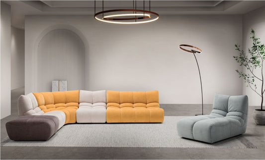 Formosa modular sofa in a contemporary living room, curved corner sectional in mustard yellow, cream and taupe fabric with a pale blue chaise longue