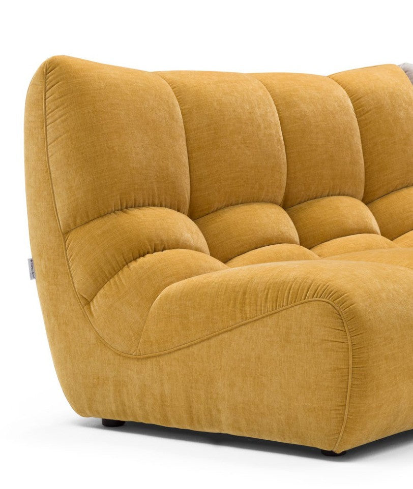 Close-up of the Formosa sofa in mustard yellow fabric showing the quilted stitching and embossed side seam