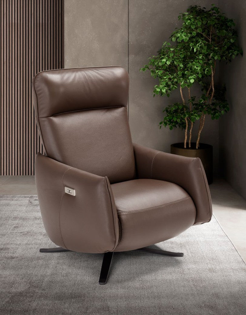 Giannetta electric recliner armchair in brown leather, three-quarter view in a modern living room with slatted wood wall and plant