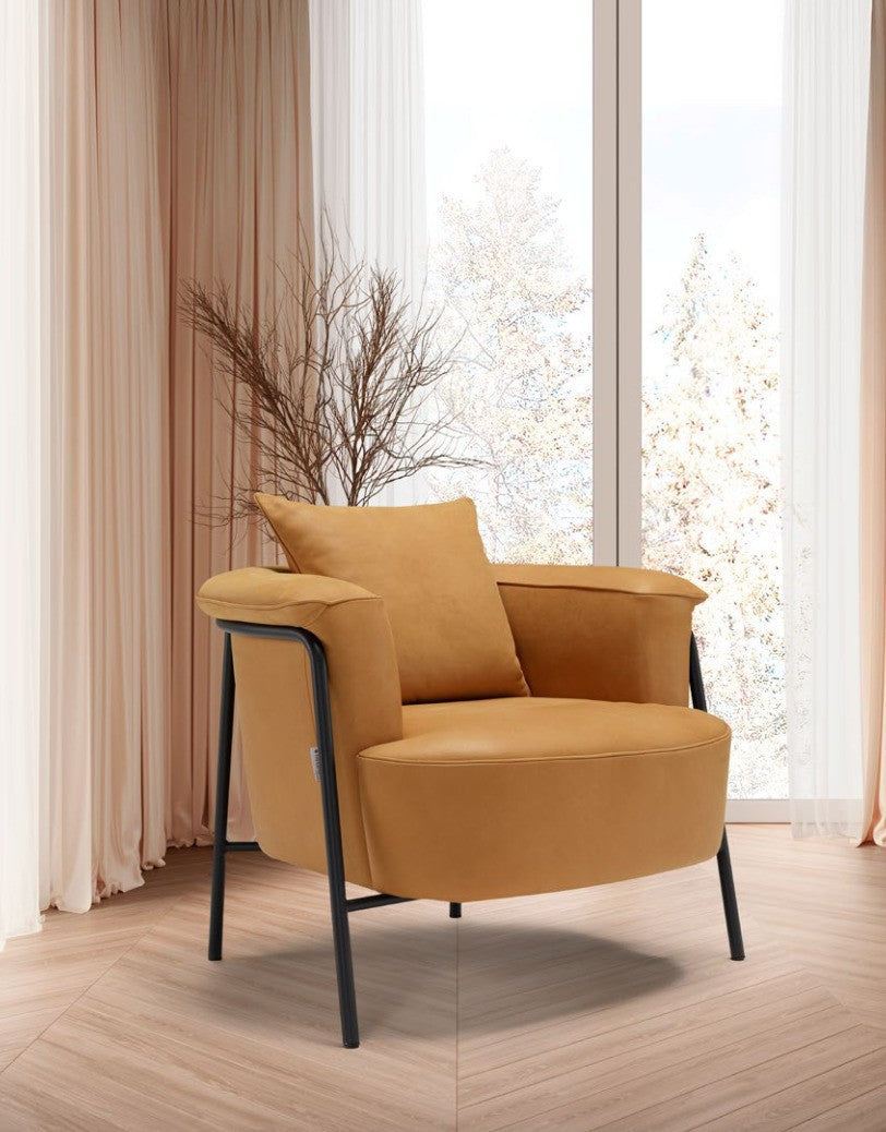 Gin armchair in tan leather with black metal frame, three-quarter view in a sunlit room with sheer curtains