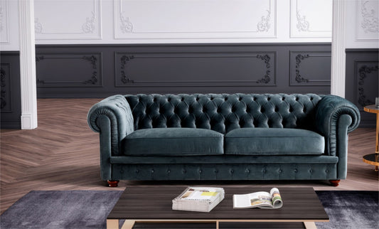 Teal velvet chesterfield sofa with rolled tufted arms in an elegant living room