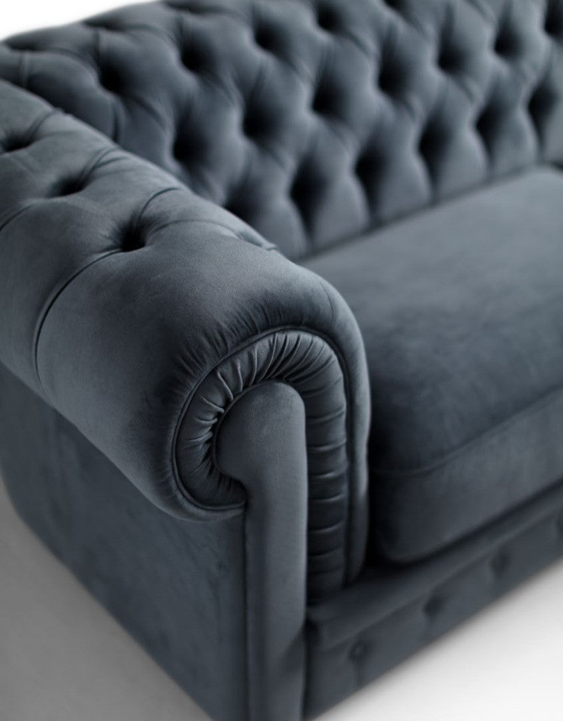 Close-up of capitonné button-tufted arm and back cushion detail on a chesterfield sofa