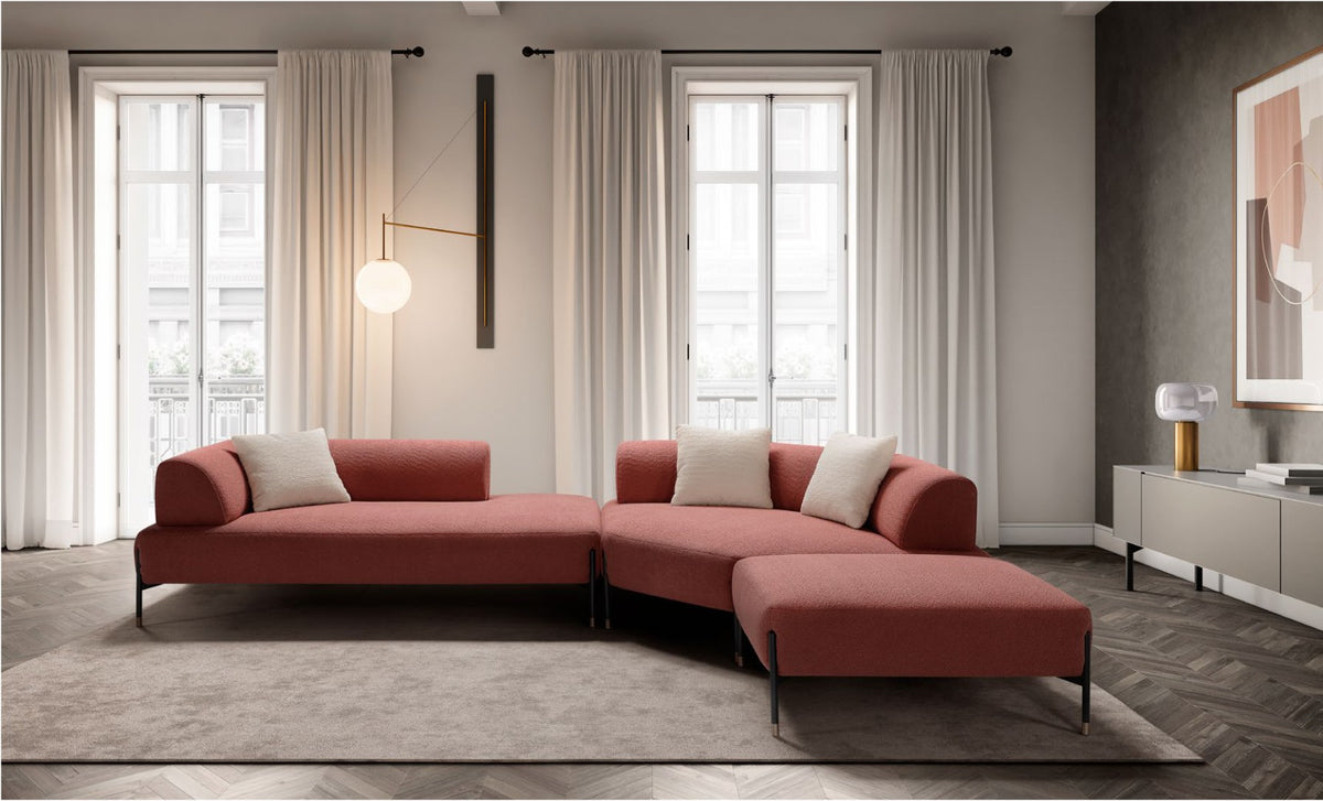 Jordan modular sofa in coral boucle fabric arranged as a corner composition with lounge elements and ottoman in a bright living room