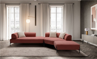 Jordan modular sofa in coral boucle fabric arranged as a corner composition with lounge elements and ottoman in a bright living room