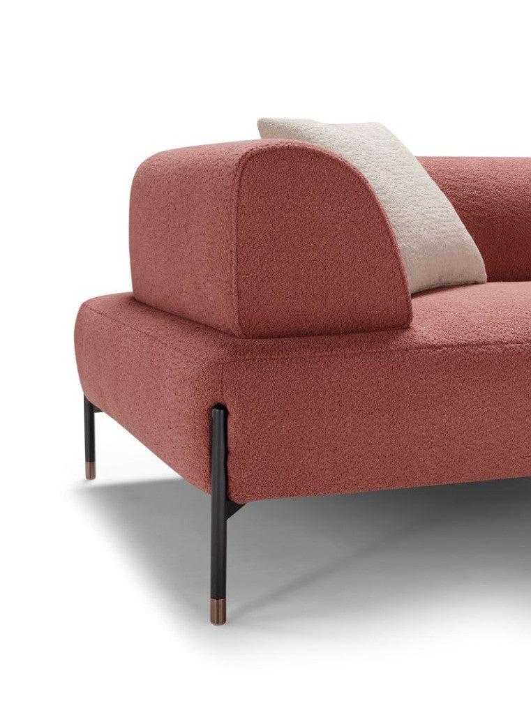 Close-up of the Jordan sofa corner in coral boucle fabric with rounded backrest and black metal leg finished with a rose gold tip