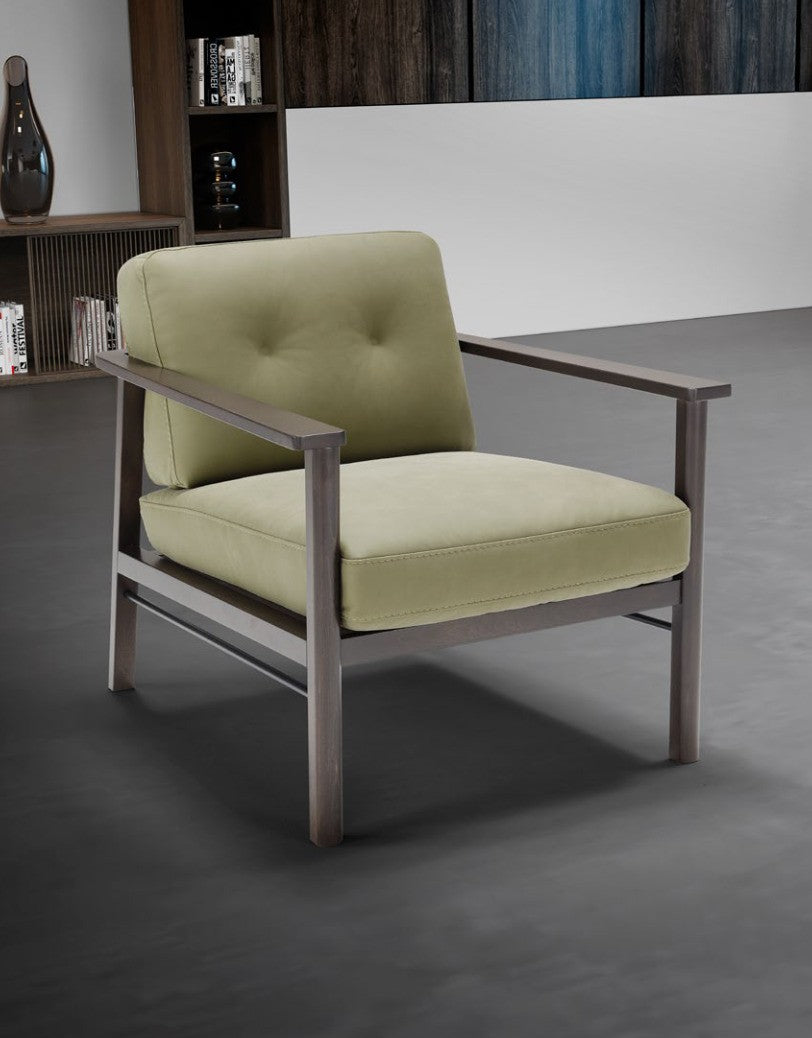 Lauro armchair in sage green leather with a wenge-toned beech wood and metal frame, three-quarter view in a contemporary living room