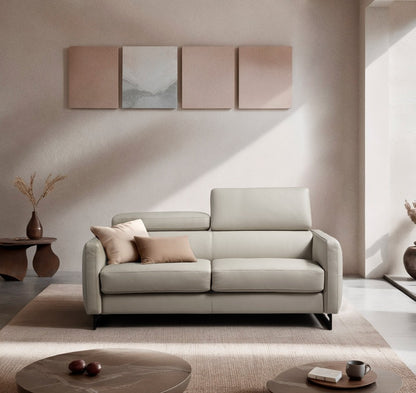 Mal sofa bed in light grey leather with adjustable headrests and black metal sled base, styled in a warm minimalist living room
