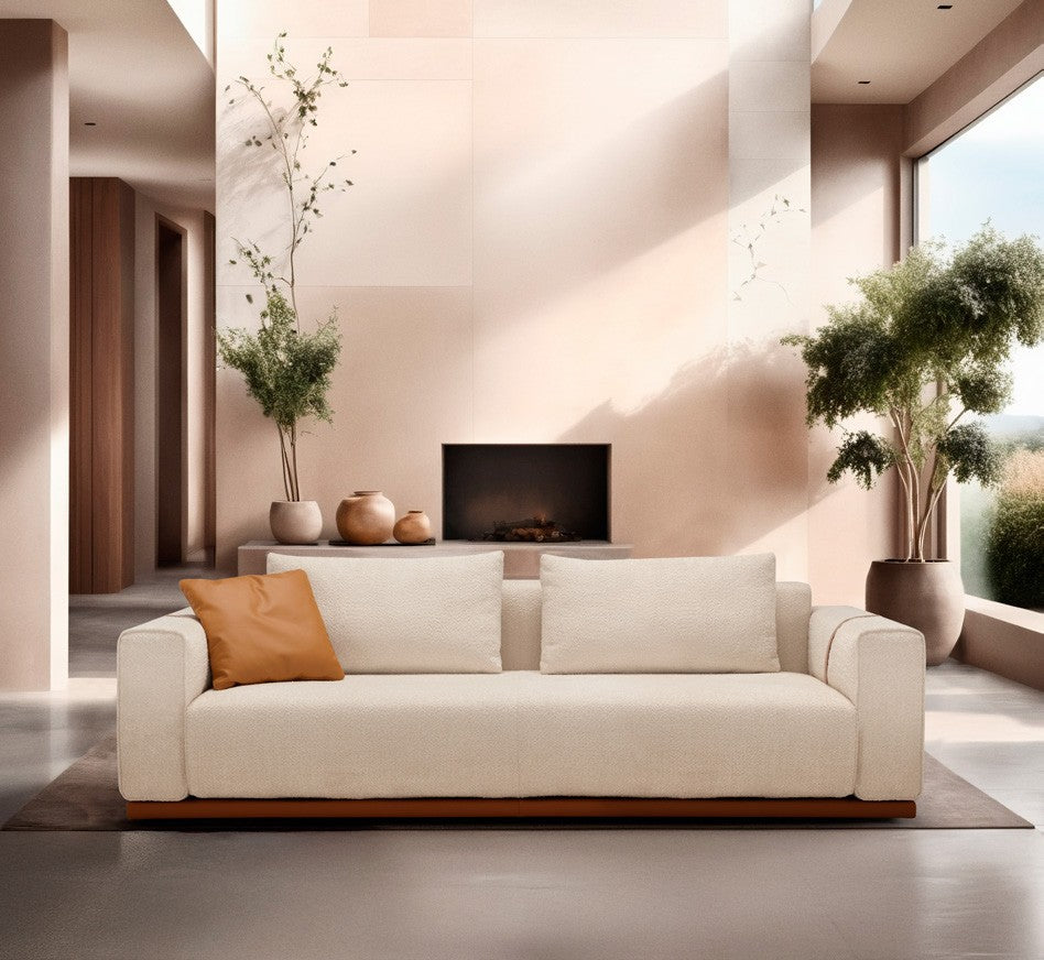 Memo sofa bed in cream fabric with a terracotta accent cushion in a sunlit contemporary living room with fireplace