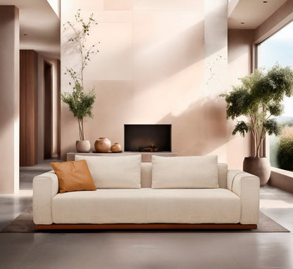 Memo sofa bed in cream fabric with a terracotta accent cushion in a sunlit contemporary living room with fireplace