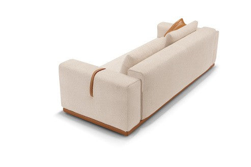 Memo sofa bed in cream fabric, rear three-quarter view showing the armrest strap detail and plinth base