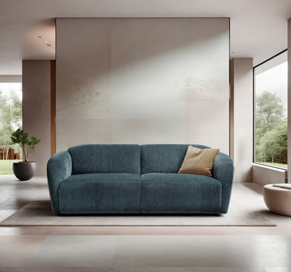 Minerva three-seater sofa bed in teal blue fabric in a bright minimalist living room with garden views