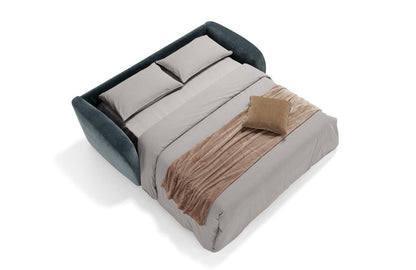 Minerva sofa bed in teal blue fabric opened into a double bed with mattress, pillows and throw