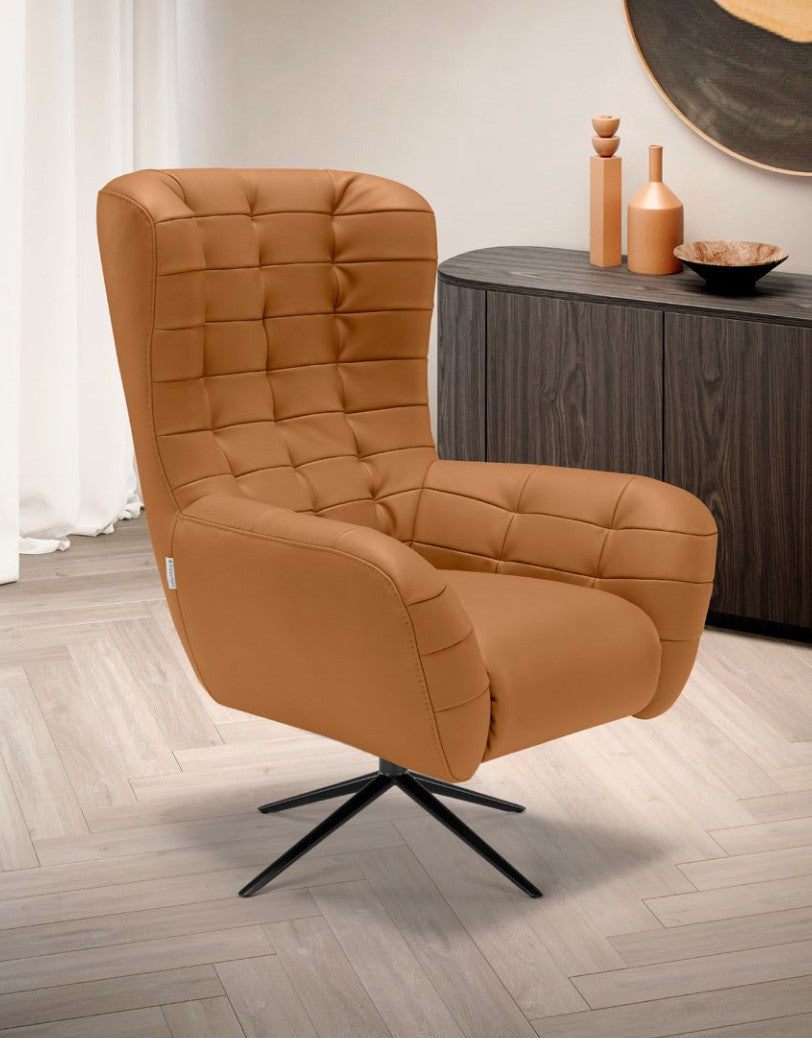Patrick armchair in cognac upholstery with capitonné quilted backrest and black four-spoke metal base, styled beside a dark wood sideboard