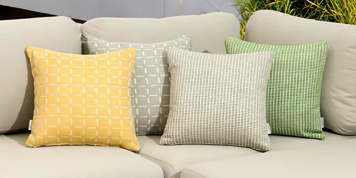 Couture Jardin decorative pillows styled on an outdoor sofa