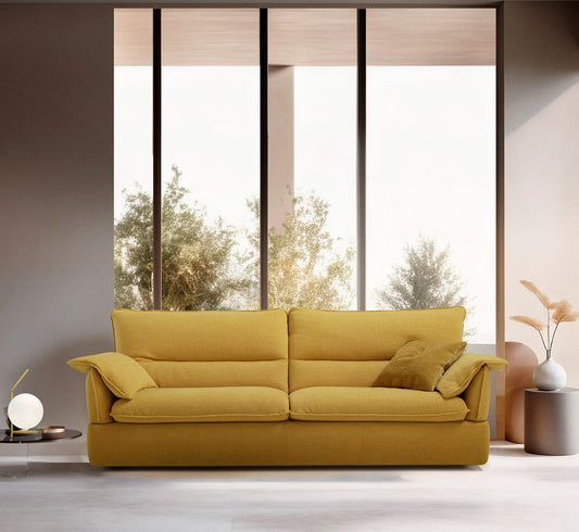 Placido sofa bed in mustard yellow fabric with soft cushions and flexible armrests in a bright living room