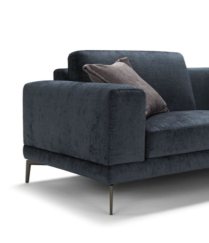 Close-up detail of the squared armrest, cushions, and slim metal leg on the navy sectional sofa