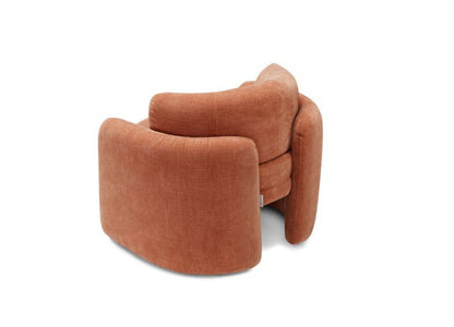 Rear three-quarter view of the Ringo armchair in terracotta fabric on a white background