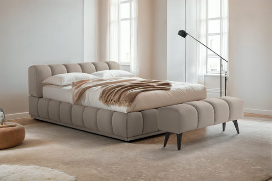 Sacai upholstered bed in warm grey with channel-stitched headboard and frame, styled in a bright bedroom with matching bench
