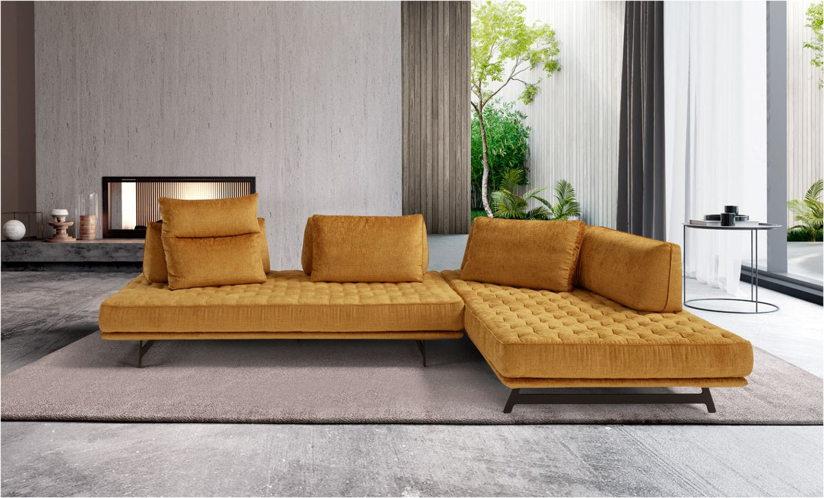 Stor sectional sofa in mustard yellow fabric with quilted seats and free-standing back cushions in a modern living room