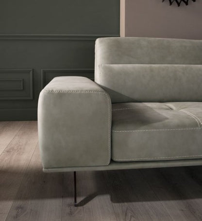 Detail of the Vanoni squared armrest with contrast stitching and slender metal leg
